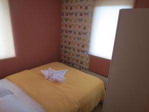 a room with a bed with a white flower on it at Apartman Žuta dunja - Sunčani breg in Kopaonik +21 photos