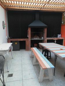 patio ze stołami i kominkiem w obiekcie Habitaciones Mar Azul w mieście El Quisco