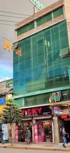 een groot groen gebouw met een klok aan de zijkant bij Hotel Las Lomas in Huancayo