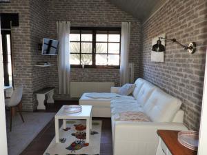 a living room with a white couch and a brick wall at Ferienhaus Eifelschätzchen am Kronenburger See in Dahlem