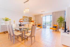 uma sala de jantar e sala de estar com mesa e cadeiras em Ocean View and Garden in Exclusive Area no Funchal