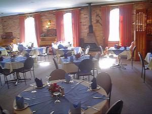a room filled with tables and chairs with blue table cloth at Coachmans Rest Motor Lodge in Coonabarabran +7 photos