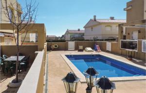 a swimming pool with two lights next to a building at 2 Bedroom Gorgeous Home In Miami Platja in Les Planes del Rei