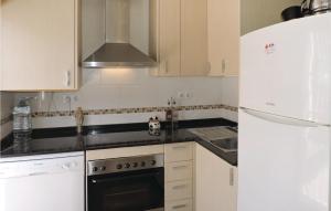 a kitchen with a white refrigerator and a stove top oven at 2 Bedroom Gorgeous Home In Miami Platja in Les Planes del Rei +6 photos