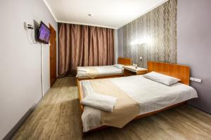 um quarto de hotel com duas camas e uma televisão em Rio Hotel em Khabarovsk