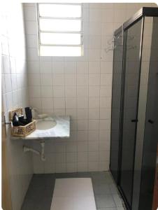 La salle de bains est pourvue d'un lavabo et d'une douche. dans l'établissement Apartamento 3 quartos , Bairro Amazonas, à Contagem