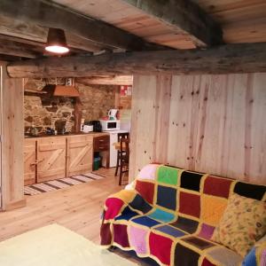 a living room with a couch and a kitchen at Casa de Baixo in Lousã