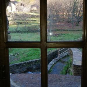 a view through a window of a bridge at Casa de Baixo in Lousã