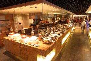 a buffet line in a restaurant with people in the kitchen at Crowne Plaza Beijing Chaoyang U-Town, an IHG Hotel in Beijing