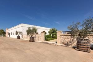 a white building with a fence and a road at Mediterranea Residence in Nardò
