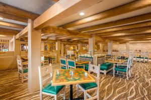um restaurante com tectos e mesas e cadeiras de madeira em Holiday Inn Canyon De Chelly-Chinle, an IHG Hotel em Chinle