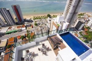 Apartamento mobiliado e confortável em candeias في ريسيفي: اطلالة على مبنى مع مسبح وشاطئ