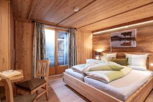 1 dormitorio con 1 cama grande y pared de madera en Achrainer-Moosen, en Hopfgarten im Brixental