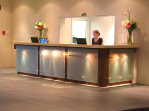 Portside Hotel Gisborne في جيسبورن: امرأة تجلس في مكتب الاستقبال في مكتب