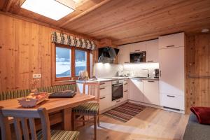 eine Küche mit einem Tisch und einer Holzdecke in der Unterkunft Achrainer-Moosen in Hopfgarten im Brixental