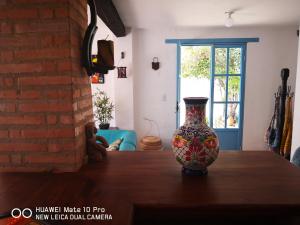 een vaas op een houten tafel bij Casa Azul Leyva in Villa de Leyva