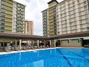 a swimming pool in the middle of two buildings at Cozy Place at Bamboo Bay Cebu in Cebu City
