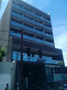 un edificio alto con ventanas azules en un lateral. en departamento salta argentina en Salta