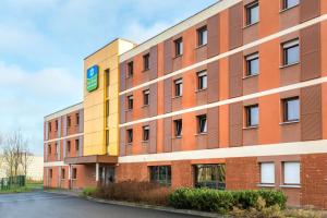 a large brick building with a sign on it at Sure Hotel by Best Western Saint-Amand-Les-Eaux in Saint-Amand-les-Eaux