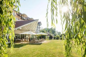 Blick auf ein Gebäude mit Tischen und Stühlen in der Unterkunft Best Western Plus Parkhotel Maximilian Ottobeuren in Ottobeuren