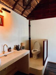 uma casa de banho com um lavatório e um WC num quarto em Libelula Tulum Beachfront Hotel em Tulum