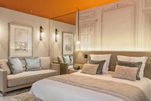 a bedroom with a large bed and a couch at Hôtel & Spa Les Sept Fontaines Best Western Premier in Tournus +54 photos