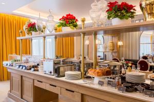 a buffet line with dishes and food on it at Hôtel & Spa Les Sept Fontaines Best Western Premier in Tournus