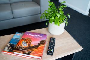 a book is sitting on top of a wooden table at Youngtown Executive Apartments - Host RNR Apartments in Launceston