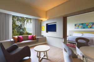 a hotel room with a bed and a living room at Mercure Penang Beach in George Town