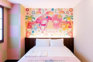 那霸的住宿－HOTEL OKINAWA WITH SANRIO CHARACTERS，卧室配有床上方的猫猫科动物绘画