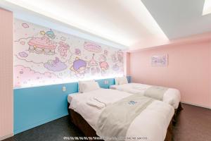 two beds in a room with hello kitty wallpaper at HOTEL OKINAWA WITH SANRIO CHARACTERS in Naha