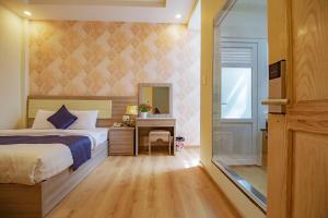 sypialnia z łóżkiem, biurkiem i lustrem w obiekcie Khanh Uyen 1 Hotel w mieście Da Lat