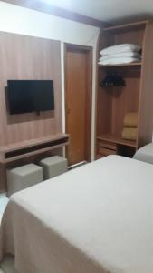 1 dormitorio con 1 cama y TV de pantalla plana en Suíte Golden Dolphin Grand Hotel, en Caldas Novas