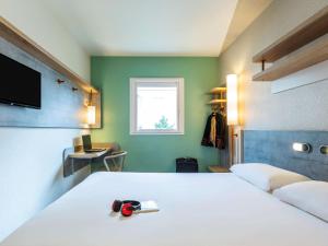 a bedroom with a large white bed and a window at ibis budget Paris Porte d'Italie Ouest in Le Kremlin-Bicêtre