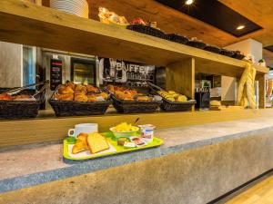 a tray of bread and pastries on a counter at ibis budget Paris Porte d'Italie Ouest in Le Kremlin-Bicêtre