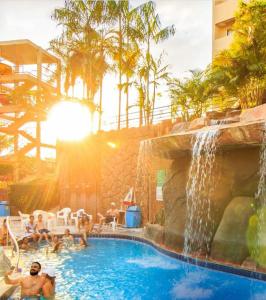 una piscina con cascada en un complejo en Suíte Golden Dolphin Grand Hotel, en Caldas Novas