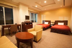 a hotel room with two beds and a table at Narita Gateway Hotel in Narita