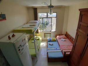 Habitación pequeña con 2 literas y nevera. en Apartamento temporada Santa Teresa, en Río de Janeiro