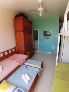 1 dormitorio con 2 camas y TV en la pared en Apartamento temporada Santa Teresa, en Río de Janeiro