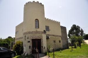 a large stone building with a tower with a door at Posada La Pausa in Miramar