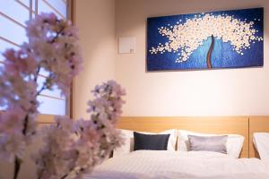 a bedroom with two beds and a painting on the wall at Sakura Stay Otorii in Tokyo