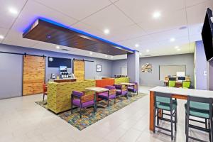 a restaurant with colorful chairs and tables in a cafeteria at Holiday Inn Express & Suites Perryton, an IHG Hotel in Lord
