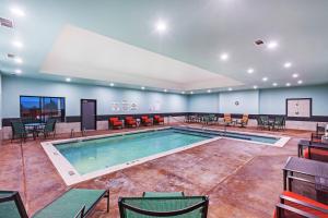 Una piscina en una habitación grande con sillas y mesas. en Holiday Inn Express & Suites Perryton, an IHG Hotel, en Lord