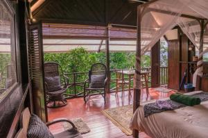 Habitación con balcón con sillas y mesa. en The Dusun, en Seremban