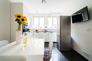 a kitchen with a table with a vase of sunflowers at 3 Rooms BIG Apartment - 150 m Town Hall - Nice Design in Wrocław