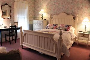 um quarto com uma grande cama branca e uma secretária em 50 Lincoln Short North Bed & Breakfast em Columbus