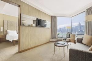 a hotel room with a couch and a bed and a table at The Kowloon Hotel in Hong Kong