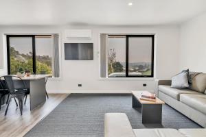 un soggiorno con divano e tavolo di Youngtown Executive Apartments - 2BR included, Free Parking & Wifi, Sofa Bed & Cot fee applies a Launceston