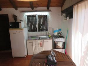 a small kitchen with a stove and a refrigerator at La Ruca in Punta Del Diablo