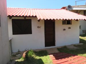 a house with a red roof and a door at La Ruca in Punta Del Diablo